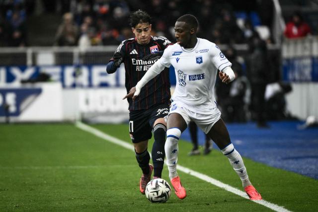 Auxerre's French defender #27 Lamine Sy dribbles past Lyon's Portuguese forward #17 Afonso Moreira (L0 during the French L1 football match between AJ Auxerre and Olympique Lyonnais at the Stade de l'Abbe-Deschamps in Auxerre, central France, on November 23, 2025. (Photo by ARNAUD FINISTRE / AFP)