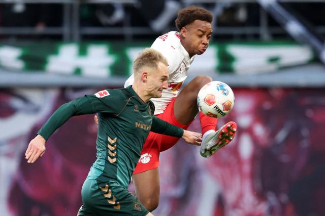 Leipzig's German midfielder #20 Assan Ouedraogo (R) and Bremen's German defender #05 Amos Pieper vie for the ball during the German first division Bundesliga football match between RB Leipzig and Werder Bremen in Leipzig on November 23, 2025. (Photo by Ronny HARTMANN / AFP) / DFL REGULATIONS PROHIBIT ANY USE OF PHOTOGRAPHS AS IMAGE SEQUENCES AND/OR QUASI-VIDEO