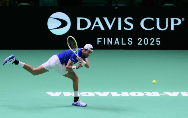 Italy's Matteo Berrettini plays a backhand return to Spain's Pablo Carreno Busta during their 2025 Davis Cup men's single final tennis match at the Super Tennis Arena in Bologna, northen Italy, on November 23, 2025. (Photo by Tiziana FABI / AFP)