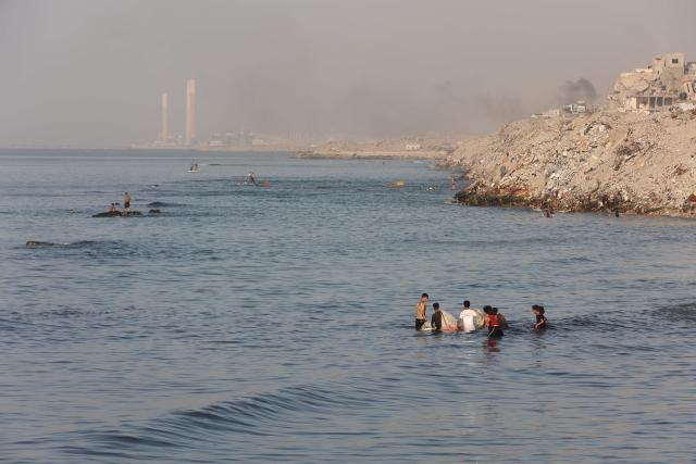 Palestinian fishermen practice fishing using small boats in the Mediterranean Sea next to Al-Shatee refugee camp beach in Gaza City, on November 23, 2025. (Photo by Omar AL-QATTAA / AFP)