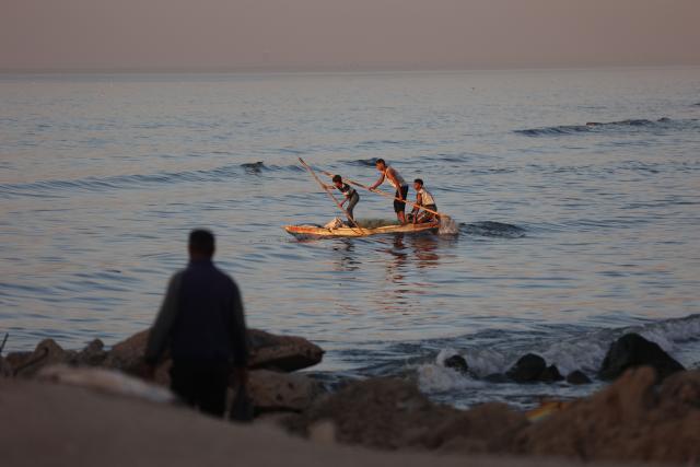Palestinian fishermen practice fishing using small boats in the Mediterranean Sea next to Al-Shatee refugee camp beach in Gaza City, on November 23, 2025. (Photo by Omar AL-QATTAA / AFP)