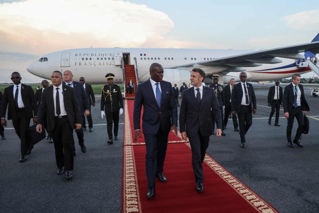 France’s President Emmanuel Macron (CR) is welcomed by Gabon's President Brice Oligui Nguema (CL) upon Macron's arrival at the Leon-Mba International Airport in Libreville on November 23, 2025. (Photo by Ludovic MARIN / AFP)