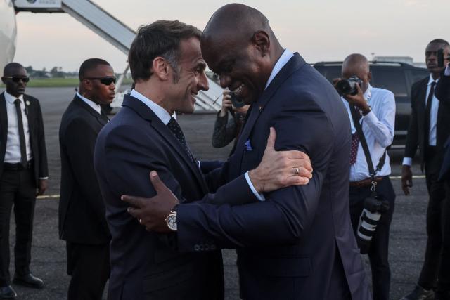 TOPSHOT - France’s President Emmanuel Macron (L) is welcomed by Gabon's President Brice Oligui Nguema (R) upon Macron's arrival at the Leon-Mba International Airport in Libreville on November 23, 2025. (Photo by Ludovic MARIN / AFP)