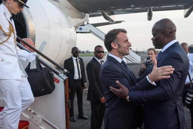 France’s President Emmanuel Macron (2nd R) is welcomed by Gabon's President Brice Oligui Nguema (R) upon Macron's arrival at the Leon-Mba International Airport in Libreville on November 23, 2025. (Photo by Ludovic MARIN / AFP)