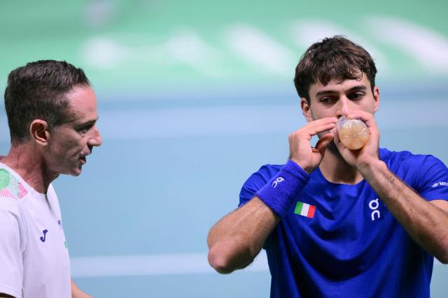 Italy's Flavio Cobolli (R) listens to Italy's team captain Filippo Volandri (L) during a break in his 2025 Davis Cup men's single final tennis match against Spain's Jaume Munar Clar at the Super Tennis Arena in Bologna, northen Italy, on November 23, 2025. (Photo by Tiziana FABI / AFP)