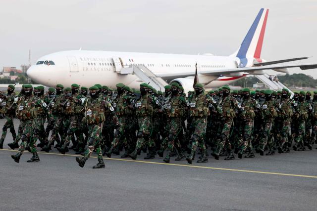 Gabon's army troops parade in front of France's President aircraft at the Leon-Mba International Airport following his arrival in Libreville before an official meeting and a press conference with Gabon's President on November 23, 2025. (Photo by Ludovic MARIN / AFP)
