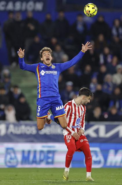 Getafe's Spanish midfielder #05 Luis Milla and Atletico Madrid's Spanish forward #10 Alex Baena fight for the ball during the Spanish league football match between Getafe CF and Club Atletico de Madrid at Coliseum Alfonso Perez Stadium in Getafe on November 23, 2025. (Photo by Oscar DEL POZO / AFP)