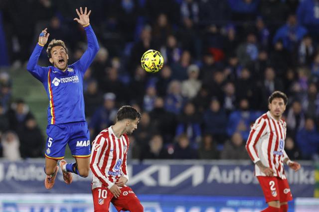 Getafe's Spanish midfielder #05 Luis Milla and Atletico Madrid's Spanish forward #10 Alex Baena fight for the ball during the Spanish league football match between Getafe CF and Club Atletico de Madrid at Coliseum Alfonso Perez Stadium in Getafe on November 23, 2025. (Photo by Oscar DEL POZO / AFP)