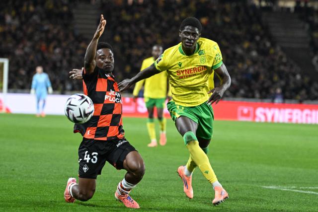 Lorient's Burkinabe defender #43 Arsene Kouassi (L) vies for the ball with Nantes' French-Guinean forward #11 Bahereba Guirassy (R) during the French L1 football match between FC Nantes and FC Lorient at the Stade de la Beaujoire–Louis-Fonteneau in Nantes, western France, on November 23, 2025. (Photo by Sebastien Salom-Gomis / AFP)