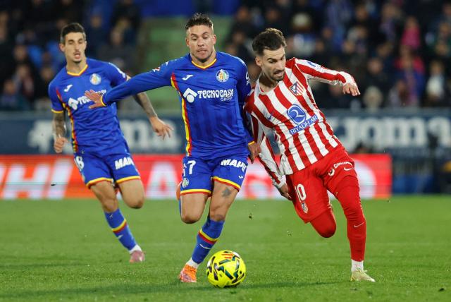 Getafe's Spanish defender #17 Francisco Femenia (C) fights for the ball with Atletico Madrid's Spanish forward #10 Alex Baena (R) during the Spanish league football match between Getafe CF and Club Atletico de Madrid at Coliseum Alfonso Perez Stadium in Getafe on November 23, 2025. (Photo by Oscar DEL POZO / AFP)