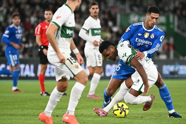 Elche's British forward #19 Grady Diangana (2R) and Real Madrid's English midfielder #05 Jude Bellingham (R) fight for the ball during the Spanish league football match between Elche CF and Real Madrid CF at Martinez Valero Stadium in Elche on November 23, 2025. (Photo by JOSE JORDAN / AFP)