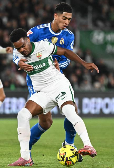 Elche's British forward #19 Grady Diangana (L) and Real Madrid's English midfielder #05 Jude Bellingham fight for the ball during the Spanish league football match between Elche CF and Real Madrid CF at Martinez Valero Stadium in Elche on November 23, 2025. (Photo by JOSE JORDAN / AFP)