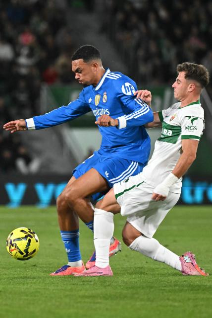 Real Madrid's English defender #12 Trent Alexander-Arnold fights for the ball with Elche's Spanish forward #11 German Valera during the Spanish league football match between Elche CF and Real Madrid CF at Martinez Valero Stadium in Elche on November 23, 2025. (Photo by JOSE JORDAN / AFP)
