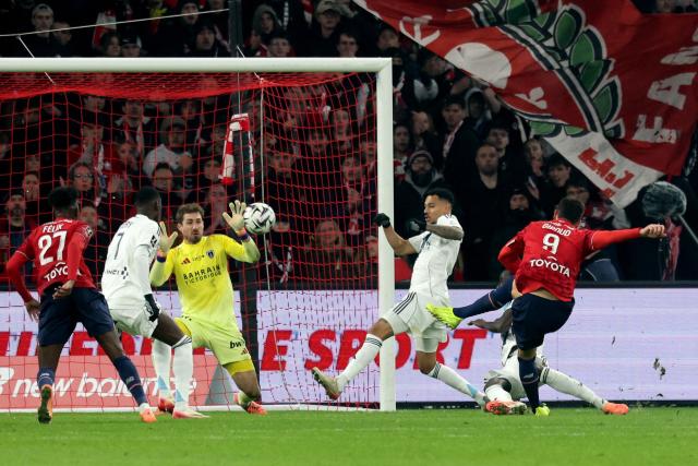 Lille's French forward #09 Olivier Giroud (R) takes a shot on goal during the French L1 football match between Lille (LOSC) and Paris FC at the Stade Pierre-Mauroy in Villeneuve-d'Ascq, northern France, on November 23, 2025. (Photo by Francois LO PRESTI / AFP)