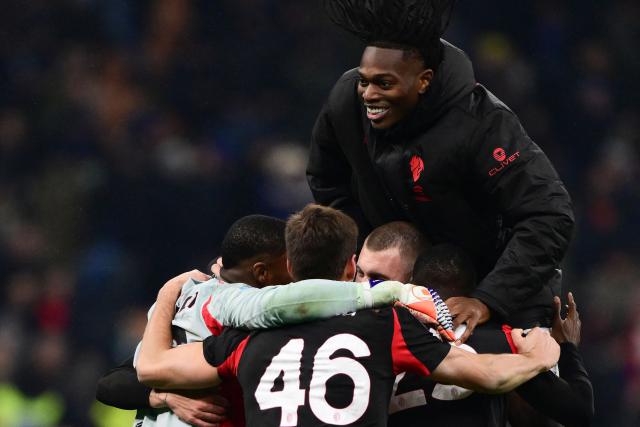 TOPSHOT - AC Milan's Portuguese forward #10 Rafael Leao (Top) celebrates with teammates at the end of the Italian Serie A football match between Inter Milan and AC Milan at San Siro stadium in Milan, northern Italy, on November 23, 2025. (Photo by Marco BERTORELLO / AFP)