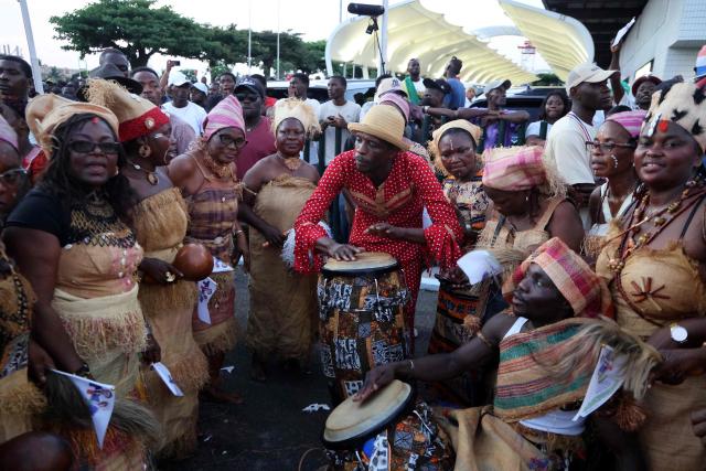 Dancers and musicians perform during a welcoming ceremony for the arrival of French president outside the Leon-Mba International Airport in Libreville on November 23, 2025. (Photo by Ludovic MARIN / AFP)