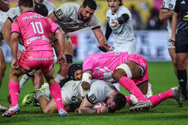 Toulon's French hooker Teddy Baubigny (down) is tackled by Stade Français' French lock Pierre-Henri Azagoh (C) during the French Top14 rugby union match between Stade Francais Paris and RC Toulon at the Jean-Bouin Stadium in Paris on November 23, 2025. (Photo by Anne-Christine POUJOULAT / AFP)