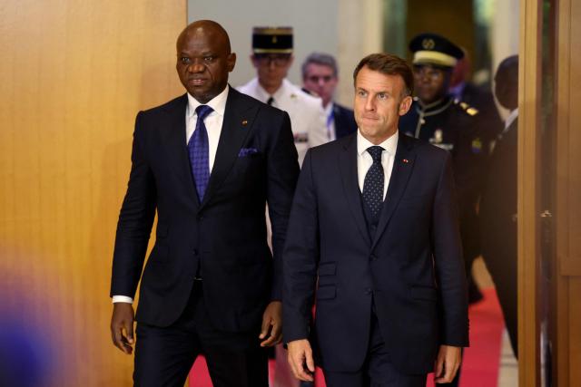 Gabon's President Brice Oligui Nguema (L) and France's President Emmanuel Macron (R) arrive to attend a contract signing ceremony following their meeting in Libreville on November 23, 2025. (Photo by Ludovic MARIN / AFP)
