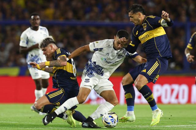 Boca Juniors' Chilean midfielder #08 Carlos Palacios and Boca Juniors' midfielder #05 Leandro Paredes (R) fight for the ball with Talleres' midfielder #08 Ulises Ortegoza during the Argentine Professional Football League 2025 Clausura Tournament round of 16 match between Boca Juniors and Talleres de Cordoba at La Bombonera Stadium in Buenos Aires on November 23, 2025. (Photo by ALEJANDRO PAGNI / AFP)