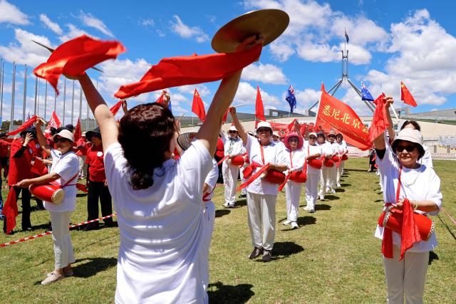 Pro-China demonstrators hold flags and display banners outside Parliament House in Canberra on November 24, 2025, during the visit of Zhao Leji, Chairman of the Standing Committee of China's National People’s Congress (NPC). (Photo by HILARY WARDAUGH / AFP)