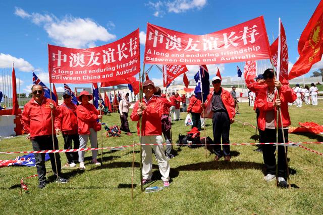Pro-China demonstrators hold banners outside Parliament House in Canberra on November 24, 2025, during the visit of Zhao Leji, Chairman of the Standing Committee of China's National People’s Congress (NPC). (Photo by HILARY WARDAUGH / AFP)