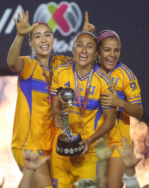 Tigres' defender #04 Greta Espinoza, forward #09 Stephany Mayor and defender #15 Cristina Ferral celebrate with the trophy after winning the Liga MX Femenil Apertura final second leg football match between Tigres and America at the Universitario Stadium in Monterrey, Nuevo Leon state, Mexico on November 23, 2025. (Photo by Julio Cesar AGUILAR / AFP)
