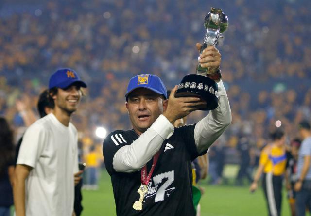 Tigres' head coach Pedro Martinez lifts the trophy after winning the Liga MX Femenil Apertura final second leg football match between Tigres and America at the Universitario Stadium in Monterrey, Nuevo Leon state, Mexico on November 23, 2025. (Photo by Julio Cesar AGUILAR / AFP)