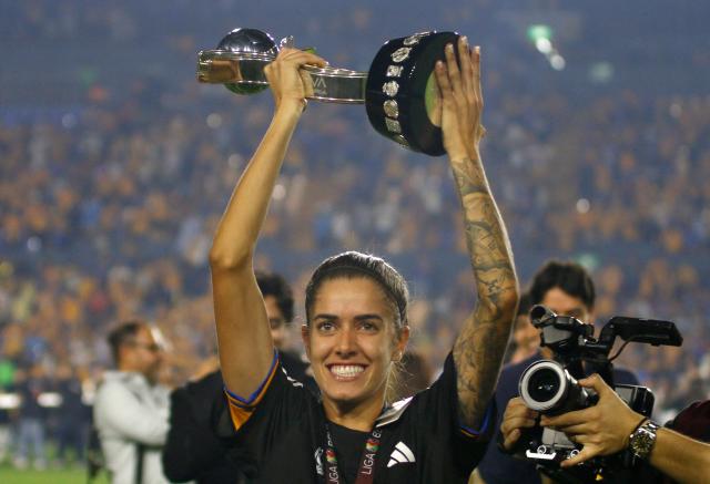 Tigres' Brazilian forward #11 Cordineli da Silva lifts the trophy after winning the Liga MX Femenil Apertura final second leg football match between Tigres and America at the Universitario Stadium in Monterrey, Nuevo Leon state, Mexico on November 23, 2025. (Photo by Julio Cesar AGUILAR / AFP)