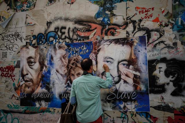 (FILES) A visitor writes on a poster displayed on the wall in front of the "Maison Gainsbourg", the home of French singer, songwriter and actor Serge Gainsbourg, on the day of its opening to the public in Paris on September 20, 2023. The court rules on the takeover bids for Maison Gainsbourg, which is under judicial reorganization, in Paris, on November 26, 2025. (Photo by Dimitar DILKOFF / AFP)
