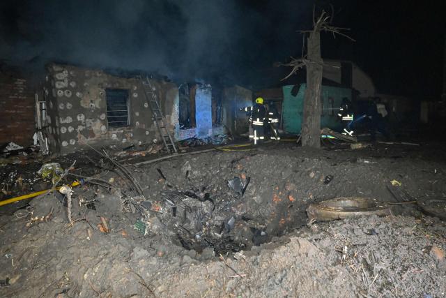 Ukrainian rescuers work at the site of a Russian drone strike in Kharkiv late on November 23, 2025, amid the Russian invasion of Ukraine. A Russian drone strike on the major Ukrainian city of Kharkiv killed four people and wounded 17 on November 23, its mayor said. The attack came as US, Ukrainian and European officials were in Geneva to discuss a proposal to end the nearly four-year war in Ukraine, which began when Russia launched a full-scale invasion. (Photo by SERGEY BOBOK / AFP)