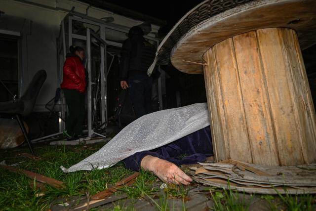 EDITORS NOTE: Graphic content / TOPSHOT - The body of a person lies in the yard of a house that was damaged by a Russian drone strike in Kharkiv early on November 24, 2025, amid the Russian invasion of Ukraine. A Russian drone strike on the major Ukrainian city of Kharkiv killed four people and wounded 17 on November 23, its mayor said. The attack came as US, Ukrainian and European officials were in Geneva to discuss a proposal to end the nearly four-year war in Ukraine, which began when Russia launched a full-scale invasion. (Photo by SERGEY BOBOK / AFP)