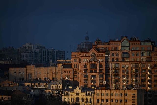 A photograph taken on November 24, 2025 shows residential buildings illuminated by a beam of sunlight during sunrise in Kyiv amid the Russian invasion of Ukraine. (Photo by Sergei GAPON / AFP)