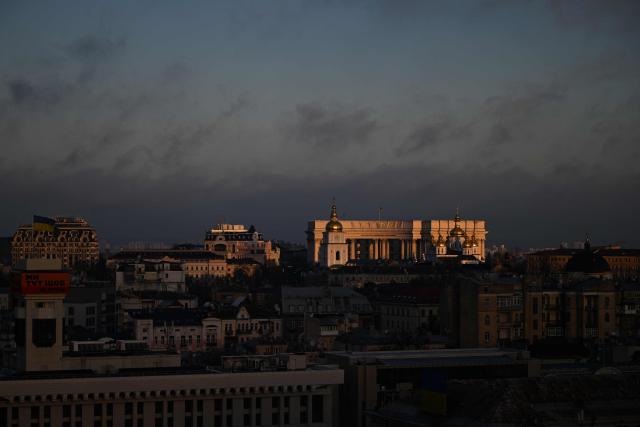 A photograph taken on November 24, 2025 shows the building of the Ukrainian Ministry of Foreign Affairs and St. Michael's Golden-Domed Monastery are illuminated by a beam of sunlight during sunrise in Kyiv, amid the Russian invasion of Ukraine. (Photo by Sergei GAPON / AFP)