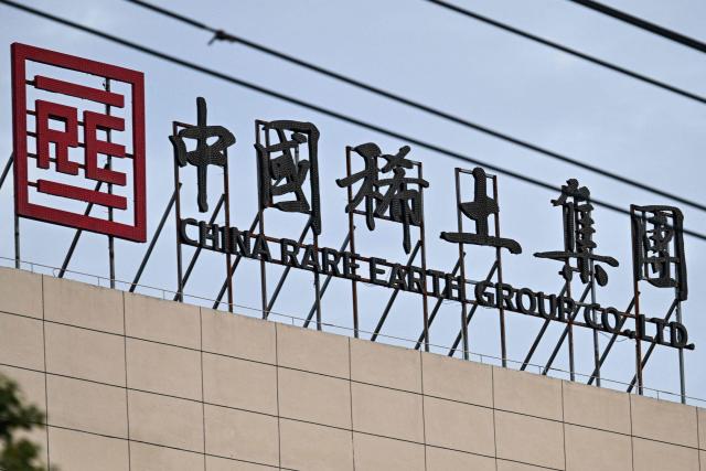 The logo and signage of the China Rare Earth Group is seen at its processing plant in Longnan county, Ganzhou, in eastern China's Jiangxi province on November 20, 2025. (Photo by Hector RETAMAL / AFP)
