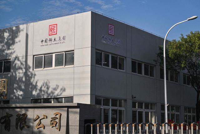 The logo of the China Rare Earth Group is seen on a building at a processing plant in Dingnan County, Ganzhou, in eastern China's Jiangxi province on November 20, 2025. (Photo by Hector RETAMAL / AFP)