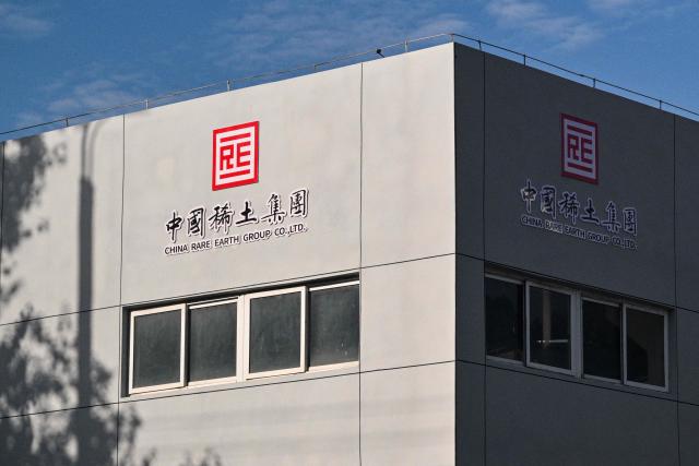 The logo of the China Rare Earth Group is seen on a building at a processing plant in Dingnan County, Ganzhou, in eastern China's Jiangxi province on November 20, 2025. (Photo by Hector RETAMAL / AFP)