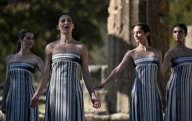 Greek actress Mary Mina (2ndL), playing the role of the High Priestess, participates in a rehearsal of the lighting of the Olympic flame for the Milano-Cortina 2026 Winter Olympic Games, in the ancient Temple of Hera at the archaeological site of Olympia, birthplace of the ancient Olympics in southern Greece, on November 24, 2025. (Photo by Aris MESSINIS / AFP)