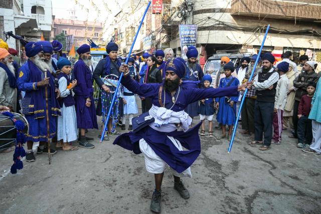 A Sikh devotee performs 'Gatka', an ancient form of Sikh martial arts during a religious procession on the eve of Guru Tegh Bahadur's martyrdom anniversary outside the Golden Temple in Amritsar on November 24, 2025. (Photo by Narinder NANU / AFP)