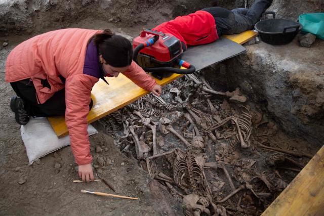 Archaeologists work to clean the remains of a body during the exhumation of bodies victims of repression executed between 1936 and 1939 during the Spanish Civil War and the Franco regime in one of several mass graves discovered in Barranco de Viznar, 10 kms north of Granada, southern Spain, on November 24, 2025. The remains of more than 160 persons have been found, of whom less than a dozen have been identified, in a total of 29 mass graves discovered in Barranco de Viznar. Spain marks the 50th anniversary of Franco's death on November 20, 1975. His regime honoured its own dead in the Spanish Civil War and left its opponents buried in unmarked graves across the country. The few surviving children of victims race against time to recover and identify the remains of their parents through DNA testing. There are over 3,300 mass graves from the Civil War and about 140,000 missing persons. (Photo by JORGE GUERRERO / AFP)