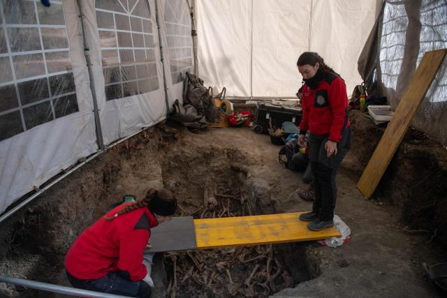 Archaeologists work to clean the remains of a body during the exhumation of bodies victims of repression executed between 1936 and 1939 during the Spanish Civil War and the Franco regime in one of several mass graves discovered in Barranco de Viznar, 10 kms north of Granada, southern Spain, on November 24, 2025. The remains of more than 160 persons have been found, of whom less than a dozen have been identified, in a total of 29 mass graves discovered in Barranco de Viznar. Spain marks the 50th anniversary of Franco's death on November 20, 1975. His regime honoured its own dead in the Spanish Civil War and left its opponents buried in unmarked graves across the country. The few surviving children of victims race against time to recover and identify the remains of their parents through DNA testing. There are over 3,300 mass graves from the Civil War and about 140,000 missing persons. (Photo by JORGE GUERRERO / AFP)