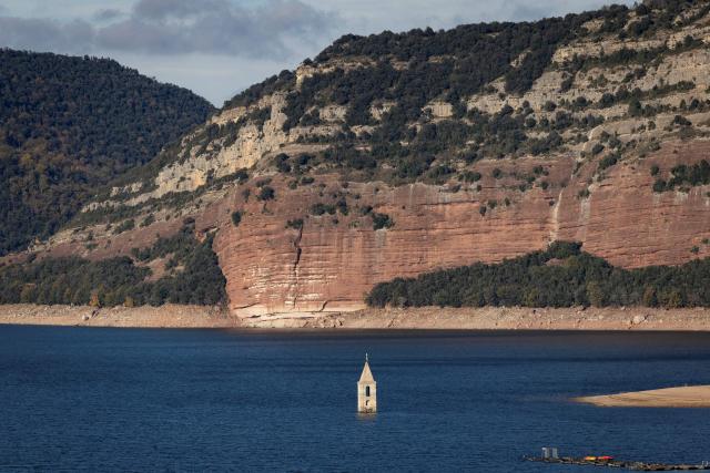 This photograph taken on November 24, 2025 shows the partially submerged bell tower of the old church of Sant Roma de Sau, in the reservoir of Sau in Vilanova de Sau in Catalonia. This long-Term project shows an inventory of several sites in Spain which are suffering from drought. Photos of the same places are taken every month over a very long period. (Photo by Josep LAGO / AFP)