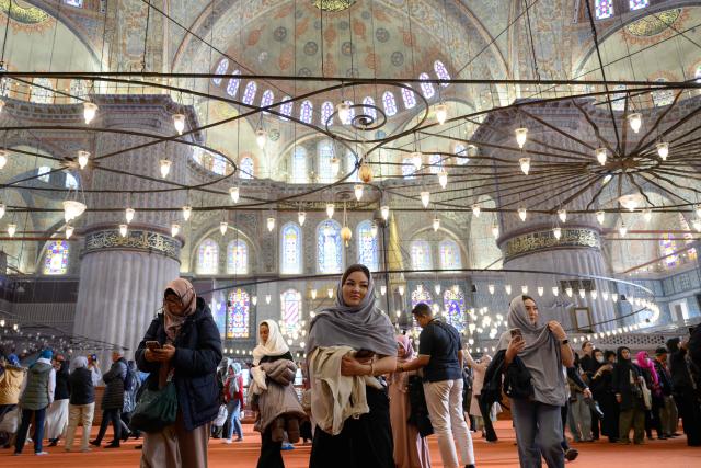 Tourists visit Sultan Ahmed Mosque, also known as the Blue Mosque, ahead of the visit of Pope Leo XIV to Turkey, in Istanbul on November 24, 2025. (Photo by Yasin AKGUL / AFP)