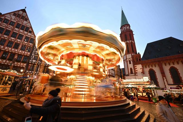 A merry-go-round is pictured at the Christmas market at the central Roemer square in Frankfurt am Main, on November 24, 2025. (Photo by Kirill KUDRYAVTSEV / AFP)