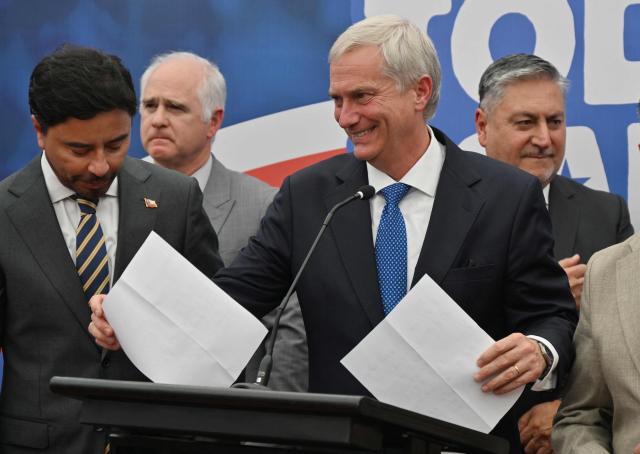 Chile's presidential candidate Jose Antonio Kast of the Republican party, smiles as he holds papers during a presser after a meeting with security advisers, in Santiago, on November 24, 2025. Leftist candidate Jeannette Jara and far-right leader Jose Antonio Kast will go head-to-head in Chile's presidential run-off after topping the first round of voting in an election dominated by fears of violent crime. (Photo by RODRIGO ARANGUA / AFP)