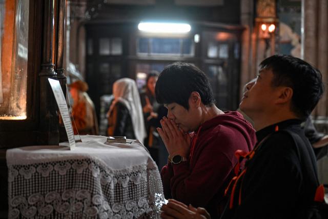 Worshippers pray as they visit Saint Anthony of Padua Church, ahead of the visit of Pope Leo XIV to Turkey, in Istanbul on November 24, 2025. (Photo by Ozan KOSE / AFP)