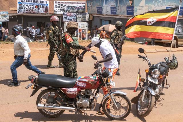 TOPSHOT - A member of Uganda's military police strikes a supporter of the National Unity Platform (NUP) presidential candidate and opposition leader Robert Kyagulanyi, also known as Bobi Wine, with a baton during a presidential campaign rally in Kampala on November 24, 2025. Bobi Wine, the main challenger to President Yoweri Museveni's 40-year rule in Uganda, drew vast crowds as he brought his campaign to the capital Kampala on November 24, 2025 ahead of January's election.
Wine, whose real name is Robert Kyagulanyi, is a 43-year-old singer turned politician who has become hugely popular among Ugandan young people but faces a deeply entrenched political machine led by the 81-year-old Museveni. (Photo by BADRU KATUMBA / AFP)