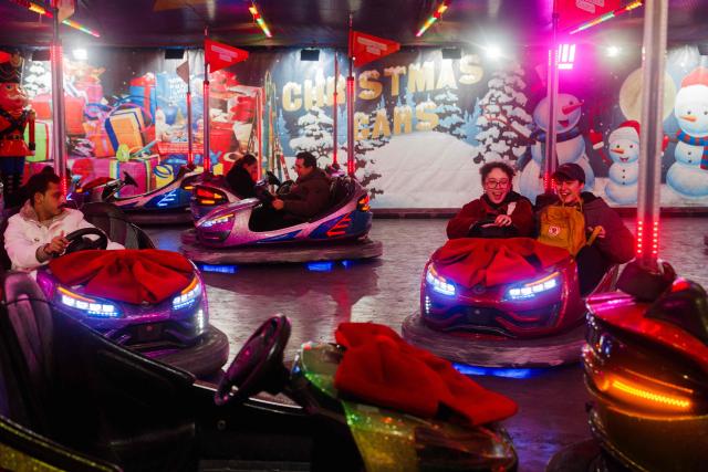 Visitors ride bumper cars at the Christmas market and fairground in the Jardin des Tuileries gardens in central Paris, on November 24, 2025. (Photo by Dimitar DILKOFF / AFP)
