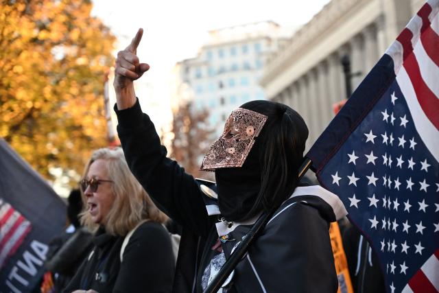People march during the "Surround the White House 1.0" protest against US President Donald Trump in front of the White House in Washington, DC, on November 24, 2025. The protest is part of a series of rallies organized by the protest group Refuse Fascism. (Photo by Alex WROBLEWSKI / AFP)