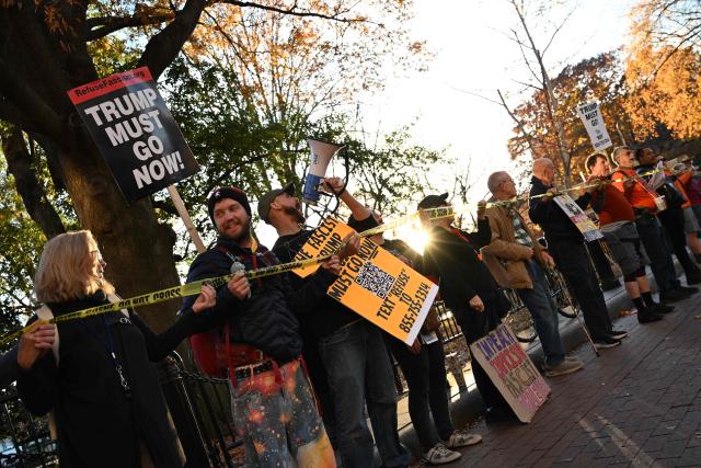 Demostrators hold signs during the "Surround the White House 1.0" protest against US President Donald Trump in front of the White House in Washington, DC, on November 24, 2025. The protest is part of a series of rallies organized by the protest group Refuse Fascism. (Photo by Alex WROBLEWSKI / AFP)