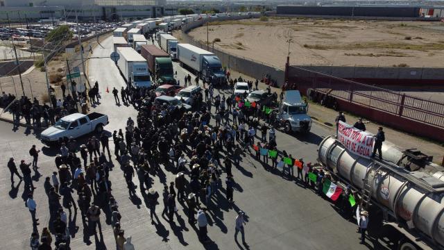 This aerial view shows truckers carrying export goods to the United States during a demonstration as part of the national farmers' strike at the Zaragoza-Ysleta International Bridge in Ciudad Juarez, Chihuahua State, Mexico on November 24, 2025. (Photo by HERIKA MARTINEZ / AFP)